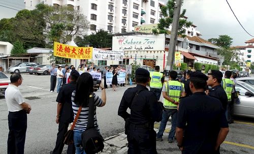 '图2：2016年12月10日国际人权日，马来西亚法轮功学员在中使馆附近举行集会，强烈谴责中共迫害，吸引了多位警官前来了解真相。'