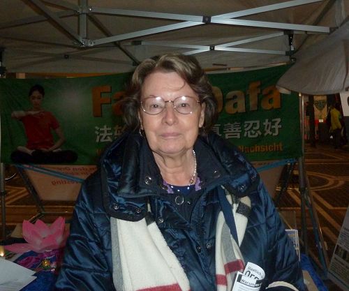 '图8：法兰克福的塞尔女士签名反对活摘器官，还想建议她来自中国的孙媳妇来法轮功信息展位看看。'