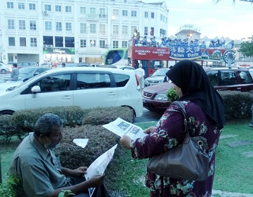 退休商人Kasim 与太太正在专注的阅读真相资料。