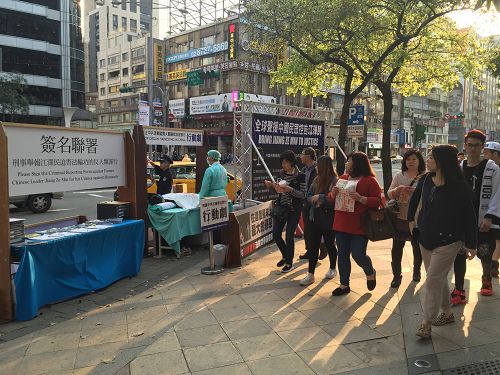 图1-2：三月六日，台北忠孝东路商圈的街头，法轮功学员举办揭露中共迫害的活动，吸引民众关注