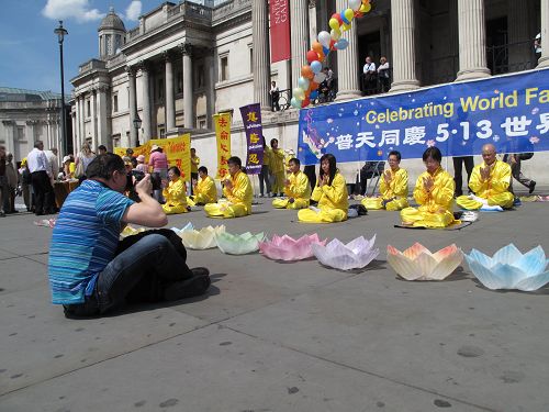 图13：经营摄影室的伦敦人保罗了解法轮功真相，五月八日，在鸽子广场再次被法轮功学员集体炼功讲真相的场面所吸引。