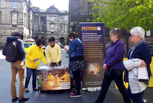 苏格兰首府爱丁堡市政厅前，法轮功学员设置展位，向民众介绍功法，揭露中共迫害。