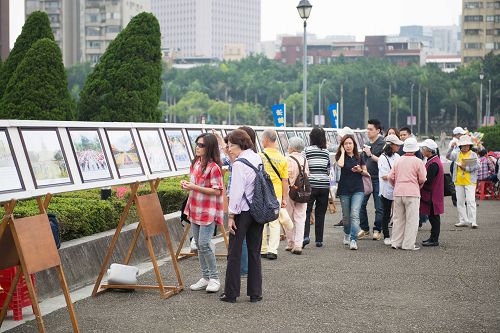 图2-4：许多游客停驻观看法轮功的真相图片展。