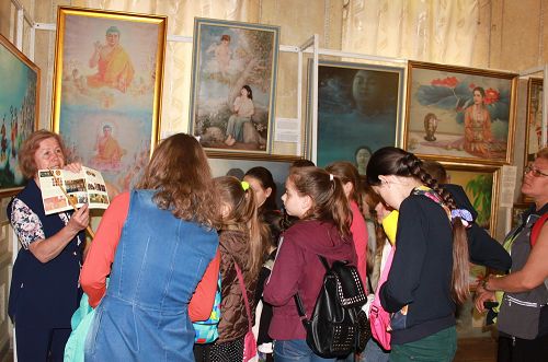 图1：法轮功学员在乌克兰哈尔科夫市举办“真善忍”国际美展，传播法轮功真相。图位，参观者倾听画展导览的解说。