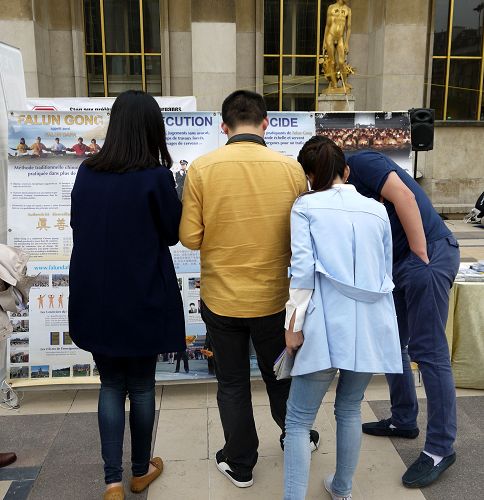 图3：巴黎人权广场上，中国大陆游客观看法轮功真相展板