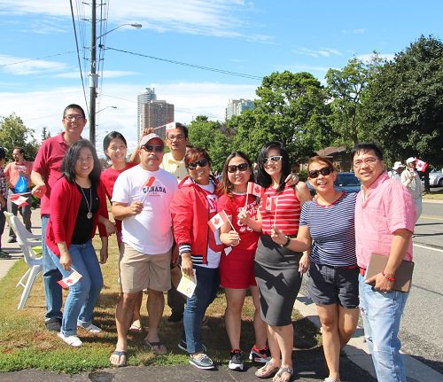 Edward（右一）和他的菲律宾社团成员在观看游行，他们表示，我们都支持法轮功！