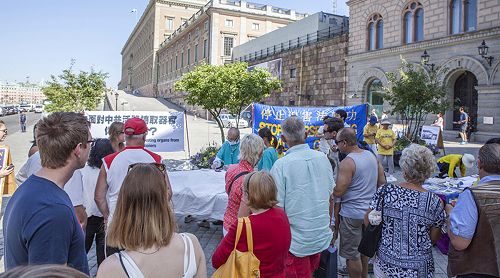 在斯德哥尔摩最热闹的皇宫旁的钱币广场，法轮功学员向民众讲真相，揭露中共迫害。