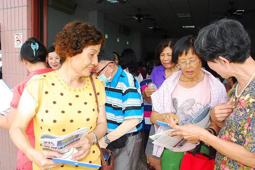 法轮功介绍会结束后，民众满脸笑容拿着真相资料高兴离去。