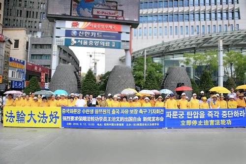 '八月十二日下午三点，韩国部份法轮功学员在中共大使馆前举行集会，敦促中共当局重新颁发护照，还给王治文自由，使其与家人团聚。'