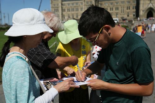 '图2-5：八月二十六日，法轮功学员在加拿大首都渥太华国会山征签，呼吁即将访华的加拿大总理敦促中共停止迫害。'