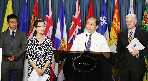 '图6：八月二十六日，加拿大部份法轮功学员在首都渥太华国会召开新闻发布会，向即将在8月末出访中国，参加G20世界首脑峰会的加拿大总理特鲁多发出呼吁：敦促中 共停止对法轮功长达十七年的迫害，释放包括十二名加拿大人的亲属在内被非法关押的法轮功学员，并将迫害元凶江泽民绳之以法。'