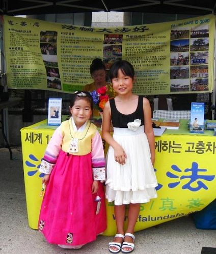 '图11：韩国小姐妹Victoria（右）和Kate（左）：我们喜欢法轮大法，也喜欢小莲花。'