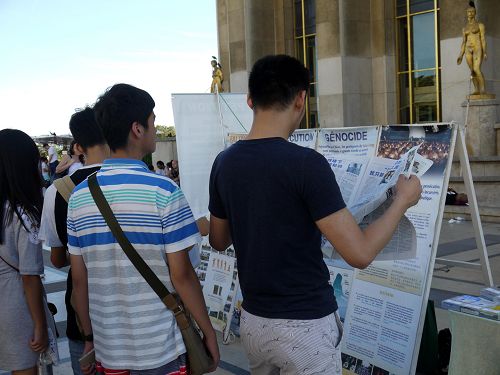 图3：巴黎人权广场，中国游客阅读法轮功真相报纸