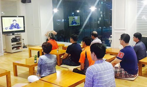 '图：新入门的学员在首尔天梯书店三楼观看法轮功创始人李洪志先生的讲法录像'