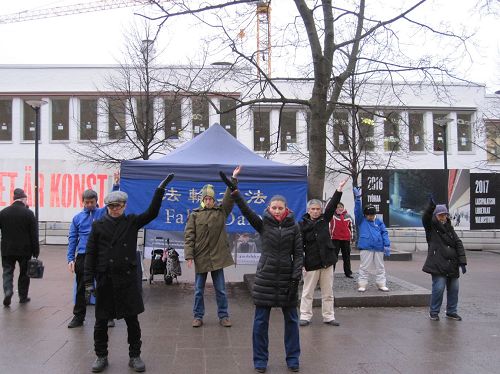 '图1：法轮功学员在芬兰首都市中心举办弘法活动，图为学员们在集体炼功'