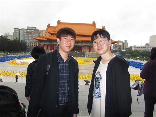 图3：韩国青年黄柄国（右）偕同友人来台旅游，对于学炼法轮功表示兴趣。