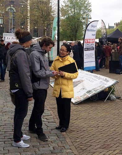 在荷兰阿姆斯特丹唐人街，路人驻足听法轮功学员讲真相