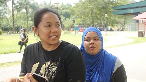 '图12：马来民众Ika（左）和Zulaihah（右）主动向学员要求签名举报迫害元凶江泽民，帮助制止迫害。'