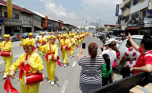 '图1～4：阵容壮观的法轮功游行队伍，在沙登新村（Seri Kembangan）浩荡出发，欢庆世界法轮大法日，受到民众的欢迎。'