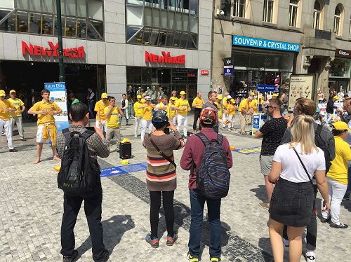 '图4:在捷克布拉格市中心,路人驻足观看法轮功学员演示功法'