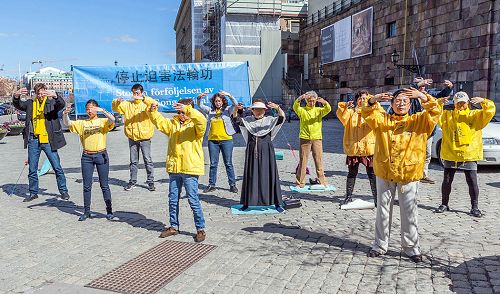 瑞典法轮功学员在斯德哥尔摩最热闹的皇宫旁的钱币广场举办讲真相反迫害集会。图为法轮功学员正在演示第二套功法—— 法轮桩法。