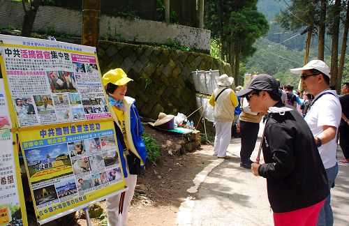 '图6-7，中国大陆游客在阿里山景点看法轮功真相展板'