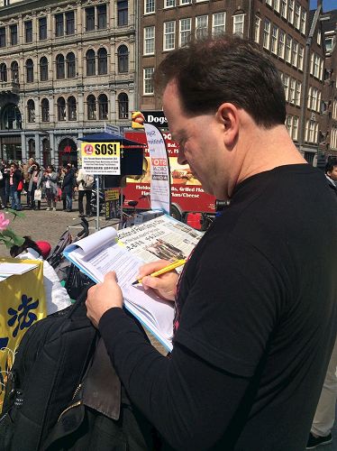 '图3-4：达姆广场上，路人了解真相后，签名支持法轮功学员反迫害'