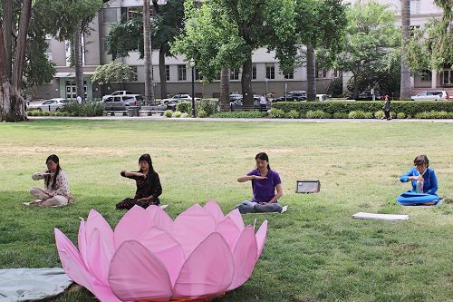 '图9:法轮功学员在祥和的炼功音乐中演示法轮功功法。'