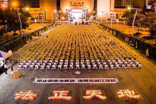 '图1：法轮功学员在台北市政府广场前举办反迫害18周年烛光悼念活动。'
