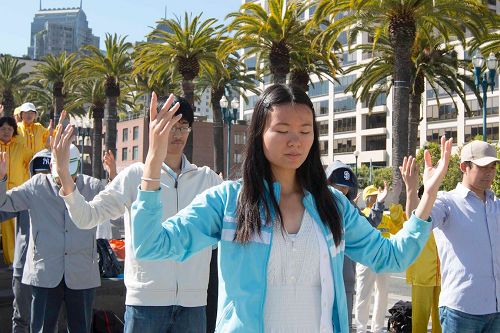'图1～2：二零一七年七月十五日一早，旧金山湾区的法轮功学员来的旧金山旅游景点之一的渡轮广场集体炼功，并告诉民众法轮功的真相。'