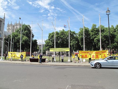 '图1：二零一七年七月十八日，英国法轮功学员在英国议会大厦前广场举行讲真相反迫害活动'