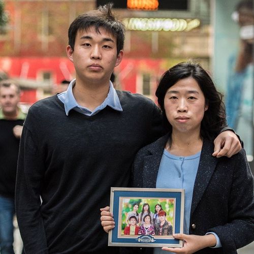 '图1：法轮功学员刘玲（右）拿着全家福照片和侄子贾明真'