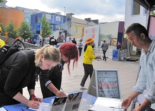 '图3～7：当天下午，芬兰学员又来首都市中心向当地民众和游客介绍法轮功的真相。不少民众驻足了解，并签名支持制止迫害。'