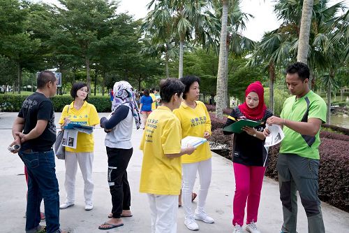 '图10:法轮功学员们向民众讲真相,大家纷纷签名,共同制止迫害。'
