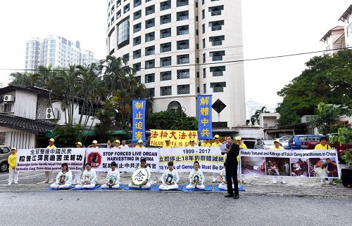 '图11：七月二十日当天，部份法轮功学员来到吉隆坡中共驻马大使馆附近举行七二零集会，引起了许多官员的关注。'