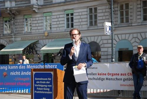 '图7：集会主持人弗洛里安（Florian）告诉驻足的民众什么是法轮功，以及今天欧洲各国法轮功学员在维也纳集会的意义。'