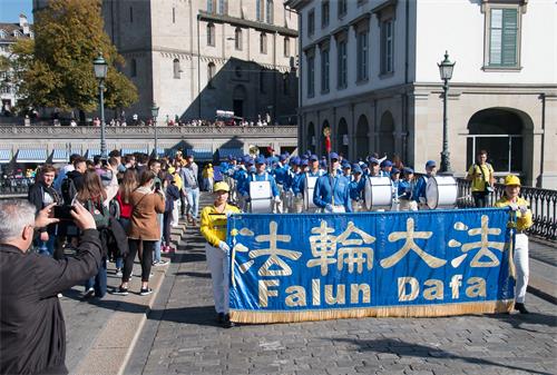 图9~11:来自各族裔的法轮功学员组成的平和的游行队伍吸引路人拍照留念