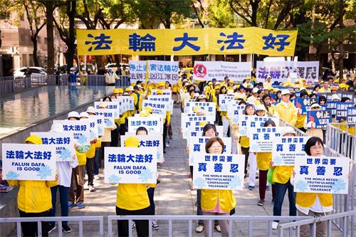 '图2：法轮功学员手举标语，传递“法轮大法好、停止迫害法轮功、法办江泽民”等呼声。'