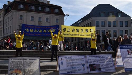 '图6-8:波兰法轮功学员在华沙古城向游客市民展示法轮功功法'