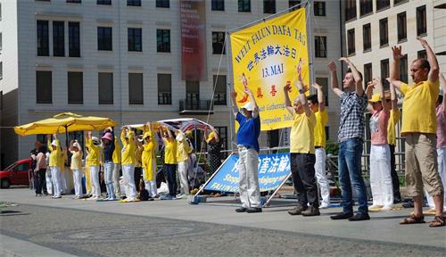 '图1：庆祝世界法轮大法日，柏林和部份莱比锡法轮功学员在柏林布兰登堡广场演示功法。'