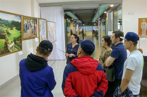 '图1～2：在俄罗斯克拉斯诺亚尔斯克市（Krasnoyarsk）的“真善忍美展”上，人们观赏画作，了解法轮功真相。'