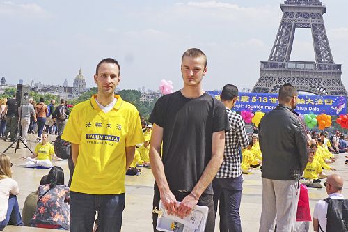 图15：法轮功学员吉佑姆（Guillaume）（左)和阿克赛尔（Axel）(右）表兄弟在巴黎人权广场参加庆祝世界法轮大法日活动。