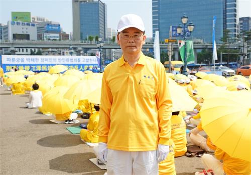 '图12：大韩法律救助公团里工作的朴钧焕先生在集会现场。'