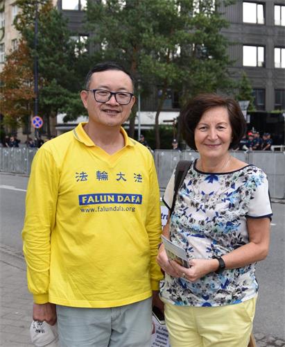 '图15:一位波兰女士非常高兴能听到法轮功学员给她介绍法轮功真相,希望学炼法轮功。'
