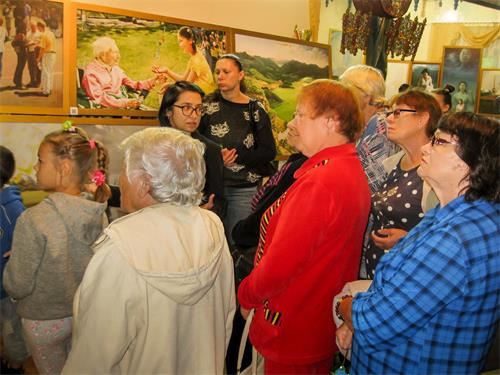 '图1～4：“真、善、忍”国际美展在俄罗斯布里亚特阿尔山展出，众多游客前来观赏。他们被画作中的故事所吸引；被中共迫害法轮功学员的残酷手段所震惊。'