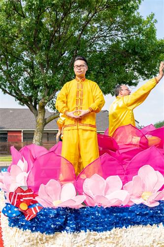 '图4：法轮功学员参加布兰诺市独立日大游行，在花车上演示功法。'