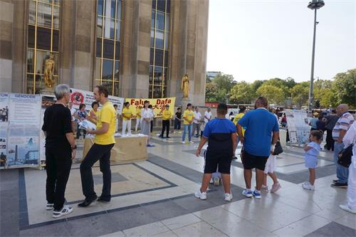 '图6：8月19日，巴黎部份法轮功学员在人权广场上和过往世界各国的游客交谈'