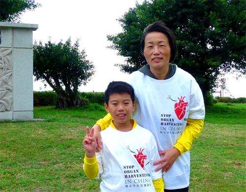 学员家菱和儿子穿上印有“制止中共活摘器官”的上衣,一起向游客讲迫害真相。