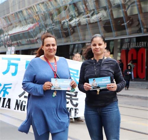 '图22：在市中心上班的塔雅（Taya 左）和她的同事拉塔莎（Latasha 右）一起观看了游行'