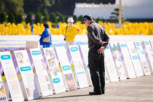 '圖7～10：自由廣場上，法輪功真相展板吸引遊客關註。'